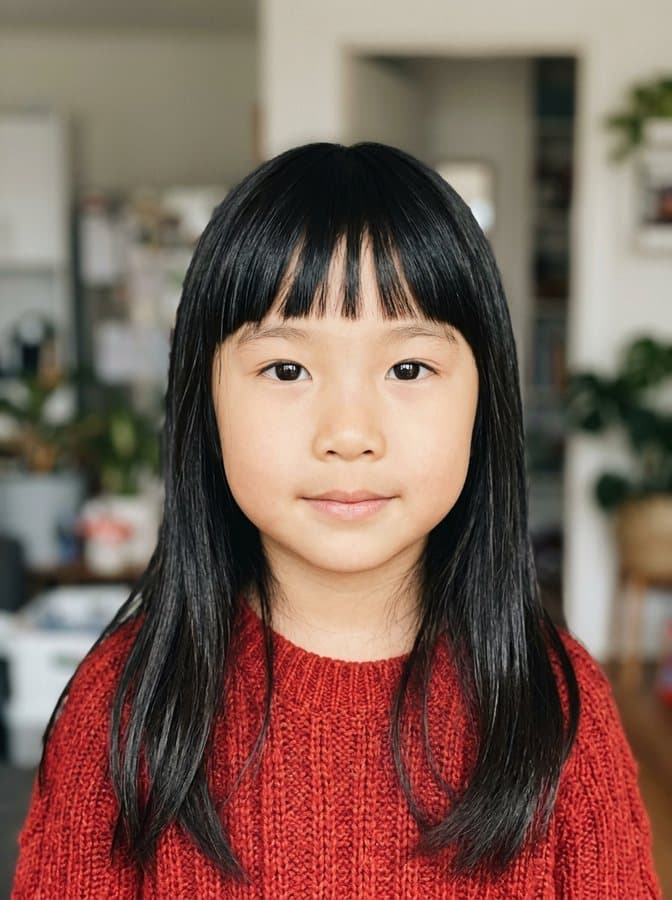 Photo of Zoë, an invented girl with long straight black hair and a fringe, made with AI